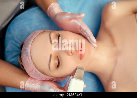 Junge Frau, die das Verfahren Zur Reinigung der Haut mit KosmetologistUltraschall besucht. Schönheitsbehandlung. Kosmetologie. Beauty Spa Salon. Stockfoto