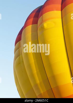 Der Heißluftballon ist aufgeblasen und gegen die Blau-Himmel-Nahaufnahme. Stockfoto