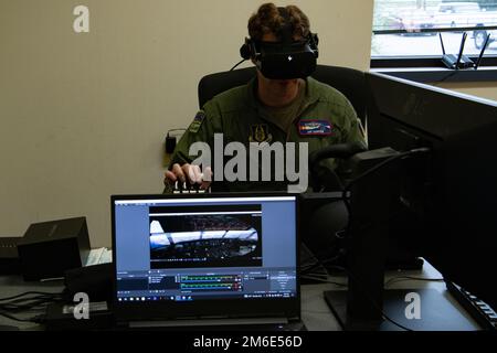 LT. Oberstleutnant Jay Capper, 731. Airlift Squadron Pilot, übernimmt die Steuerung eines Virtual-Reality-Simulators während der jährlichen Schulung zum modularen bordseitigen Feuerlöschsystem in Gowen Field, Idaho, 26. April 2022. Die Maschine wurde entwickelt, um die Bedingungen wiederherzustellen, die Piloten bei der Brandbekämpfung aus der Luft erleben, wenn sie zur Bekämpfung von Waldbränden aufgerufen werden. (USA Air Force Tech. Sgt. Justin Norton) Stockfoto