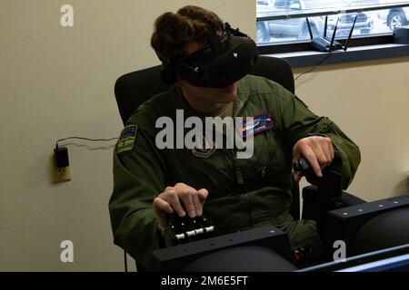 LT. Oberstleutnant Jay Capper, 731. Airlift Squadron Pilot, übernimmt die Steuerung eines Virtual-Reality-Simulators während der jährlichen Schulung zum modularen bordseitigen Feuerlöschsystem in Gowen Field, Idaho, 26. April 2022. Die Maschine wurde entwickelt, um die Bedingungen wiederherzustellen, die Piloten bei der Brandbekämpfung aus der Luft erleben, wenn sie zur Bekämpfung von Waldbränden aufgerufen werden. (USA Air Force Tech. Sgt. Justin Norton) Stockfoto