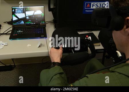 LT. Oberstleutnant Jay Capper, 731. Airlift Squadron Pilot, übernimmt die Steuerung eines Virtual-Reality-Simulators während der jährlichen Schulung zum modularen bordseitigen Feuerlöschsystem in Gowen Field, Idaho, 26. April 2022. Die Maschine wurde entwickelt, um die Bedingungen wiederherzustellen, die Piloten bei der Brandbekämpfung aus der Luft erleben, wenn sie zur Bekämpfung von Waldbränden aufgerufen werden. (USA Air Force Tech. Sgt. Justin Norton) Stockfoto