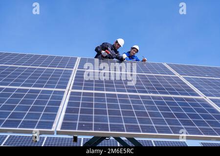 Wartungsingenieur am Solarparkstand auf dem Scherenlift, Inspektion des Solarmoduls und Reparatur Stockfoto