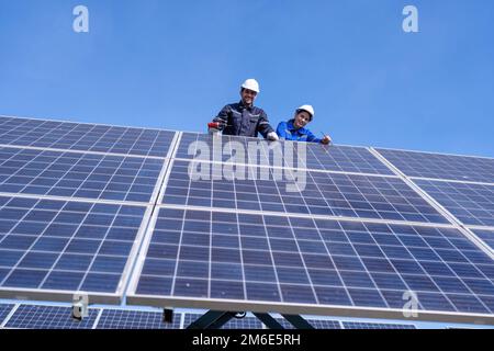 Wartungsingenieur am Solarparkstand auf dem Scherenlift, Inspektion des Solarmoduls und Reparatur Stockfoto