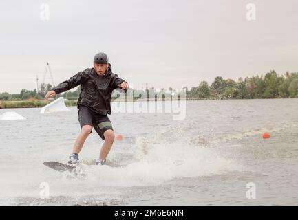 Bielawa, Polska. 03/06/2020 Wawa Wake. Ein Sportler fährt auf einem Wakeboard. Ein Mann in Sportbekleidung schwimmt auf einem See in einem Wakeboard-Park Stockfoto