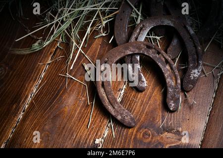 Equesrtian Hintergrund. Lucky alte Hufeisen an Holz- Hintergrund. Stockfoto