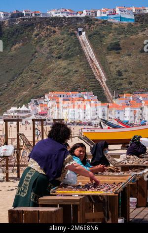 Eine Fischerin, die Trockenfisch am Strand verkauft Stockfoto