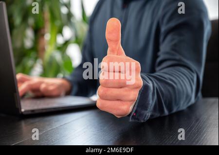 Der Mann an der Rezeption zeigt die „Daumen hoch“-Geste Stockfoto