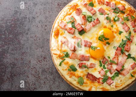 Traditionelle Pizza Carbonara mit Ei, Sahne, geräuchertem Speck, Parmesan und Mozzarella Käse. Horizontale Draufsicht von oben Stockfoto