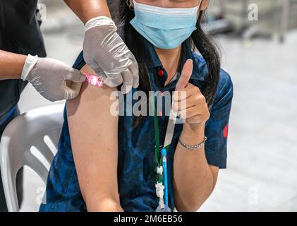 Yonung Woman mit Aufkleber „wurde geimpft“ auf Sholder nach der Injektion des Impfstoffes. Stockfoto