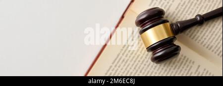 Hintergrunddetails mit Hammer auf offenem Gesetzbuch isoliert auf weißem Tisch. Draufsicht Stockfoto