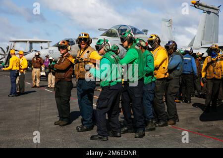 PHILIPPINISCHE SEE (26. April 2022) Seeleute bekämpfen einen simulierten Brand während Übungen im Cockpit an Bord des Flugzeugträgers USS Abraham Lincoln (CVN 72) der Nimitz-Klasse. Die Abraham Lincoln Strike Group befindet sich in einem geplanten Einsatz im US-7.-Flottenbereich, um die Interoperabilität durch Allianzen und Partnerschaften zu verbessern und gleichzeitig als einsatzbereite Truppe zur Unterstützung einer freien und offenen Region Indo-Pacific zu fungieren. Stockfoto