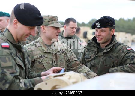 USA Army 1. LT. Christopher Landin, Alpha-Kompanieführer, dem 2. Bataillon, dem 34. Panzerregiment, dem 1. Panzerbrigade-Kampfteam, der 1. Infanterie-Division zugeteilt, spricht mit einem polnischen Soldaten über die Funktionen des M1A2 Abrams-Panzers im Rahmen des Abrams-Gipfels in Drawsko Pomorskie, Polen, April 26, 2022. Die 1. Infanterieabteilung ist unter anderem dem V-Korps zugewiesen, das neben den Alliierten im europäischen Theater arbeitet und weiterhin ein integraler Bestandteil des Demonstrationsvorhabens für die Bereitschaft, Interoperabilität und Fähigkeiten der Allianz ist. Stockfoto