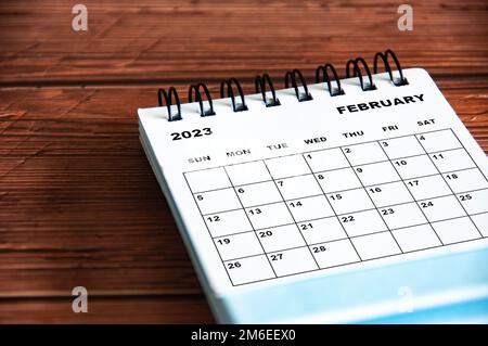 Februar 2023 weißer Tischkalender auf Holzhintergrund. Stockfoto