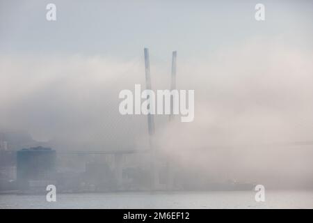 Die Goldene Brücke in Wladiwostok ist von dichtem Nebel umhüllt Stockfoto