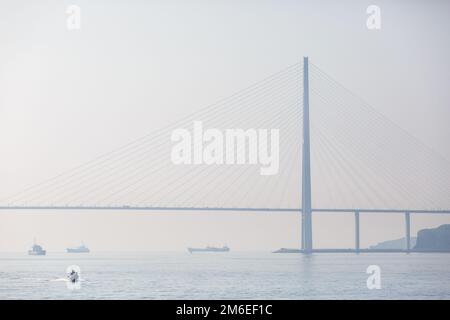 Die russische Brücke in Wladiwostok ist von dichtem Nebel umhüllt Stockfoto