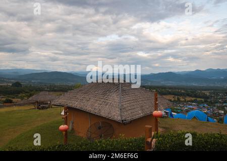 Abendlandschaft mit traditionellem thailändischem Haus im Vordergrund vom Yun Lai Aussichtspunkt in Pai, Nord-Thailand Stockfoto