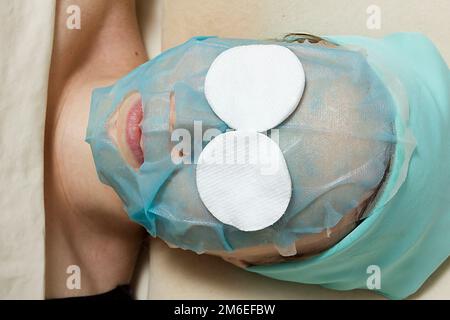Junge Frau mit einer kosmetischen Maske im Gesicht Stockfoto