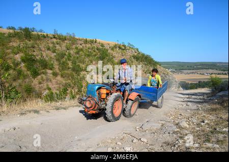 Minitraktor mit Fahrgästen auf der unbefestigten Bergstraße im Norden Moldawien Stockfoto