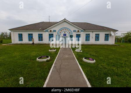 Weiß getünchtes Gebäude einer alten einstöckigen Schule im Dorf Stockfoto