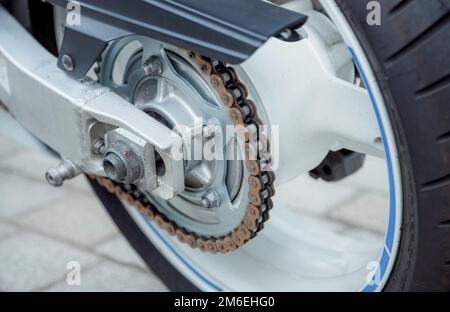 Teil des Hinterrads eines Motorrads. Kette an einem Motorrad. Maschinen. Stockfoto