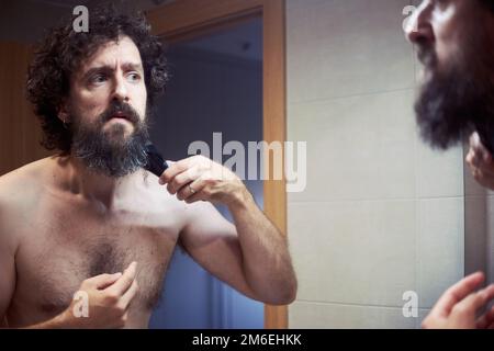 hispanischer Mann mittleren Alters, der sich den Bart schneidet Stockfoto