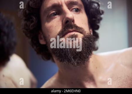 hispanischer Mann mittleren Alters, der sich den Bart schneidet Stockfoto