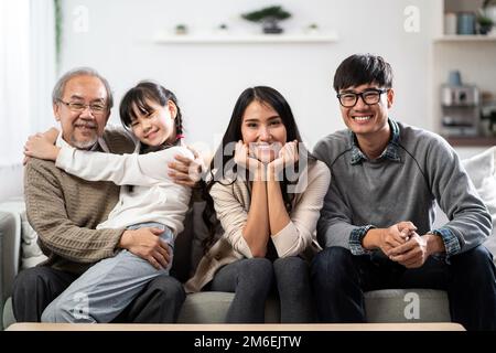 Fröhliches Mehrgenerationenporträt einer asiatischen Familie im Wohnzimmer Stockfoto