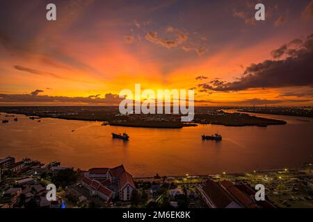 Vogelperspektive auf Samut Prakan, Thailand. Sonnenuntergang über dem Chao Phraya Fluss, orangefarbener Himmel. Stockfoto