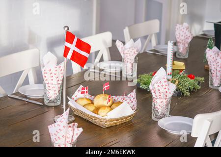 Traditioneller dänischer Geburtstagstisch mit Flaggen und frischen Brötchen aus dem Ofen. Stockfoto