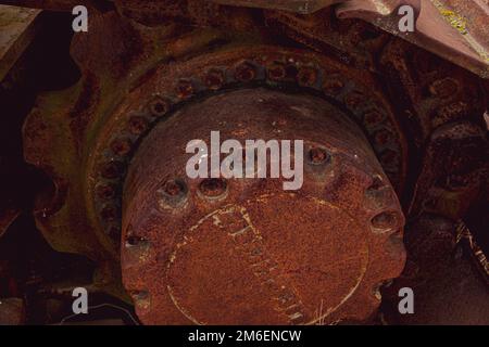 Rusty und Schmutz bedeckt mechanische Caterpillar Track mit Alter Räder und Rollen. Stockfoto