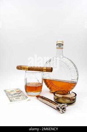 Hochwertige Zigarren mit Cognac, Cutter, 100-Dollar-Papier und Aschenbecher auf weißem Hintergrund Stockfoto