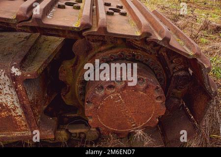 Rusty und Schmutz bedeckt mechanische Caterpillar Track mit Alter Räder und Rollen. Stockfoto