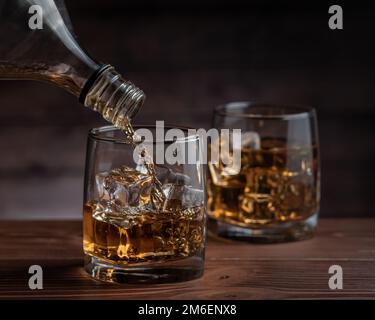 Cognac wird aus einer Flasche gegossen Stockfoto