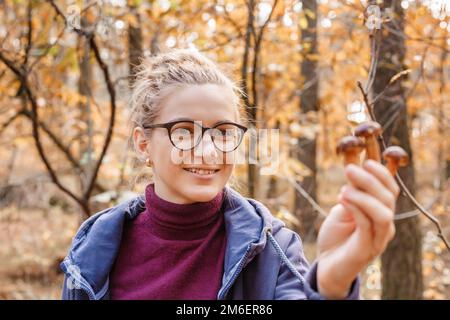 Herbstzeit. Pilze in den Händen. Pilze pflücken. Geschenke des Waldes. Hände und Pilze. Bein und Hut. Stockfoto