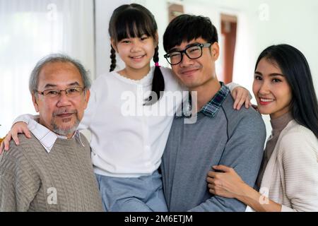 Fröhliches Mehrgenerationenporträt einer asiatischen Familie im Wohnzimmer Stockfoto