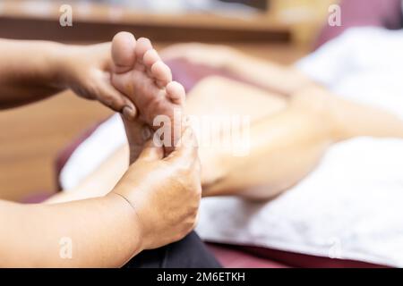 Neue normale asiatische Frau mit Gesichtsmaske tun Massage zu Hause close up. Stockfoto