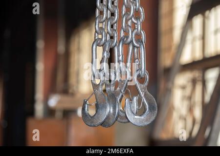 Metallketten mit Haken in der Werkstatt eines metallurgischen Werks. Stockfoto