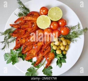 Gekochte Garnelen mit frischen Kräutern, Oliven, Limette und Tomaten Stockfoto