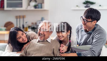 Glückliches, generationsübergreifendes asiatisches Familienporträt im Wohnzimmer mit Panoramablick Stockfoto