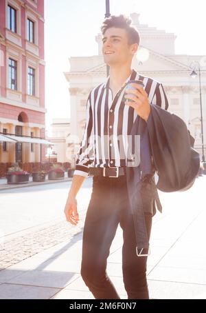 Ein hübscher, stylischer Mann in einer Jeansjacke, Hipster. Ein junger Mann läuft durch die Stadt. Ein stylischer Kerl in stilvollen Kleidern und einem Bla Stockfoto