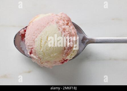 Vanille- und Erdbeereiskugel in einem Löffel, Draufsicht Stockfoto