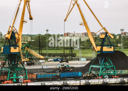 Eisenbahnwaggons Beladen Kohle. Maschinen, Mechanismen. Turmkräne An Der Ladestation. Kohlewagen, Bergbau Und Gütertransport Von Mineralien Mit Der Bahn Stockfoto