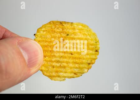 Handgehaltene Kartoffelchips isoliert auf weißem Hintergrund Stockfoto