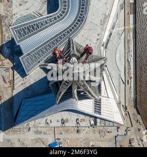 Arbeiter, die in der Höhe arbeiten, arbeiten oben auf dem Wolkenkratzer. Stockfoto