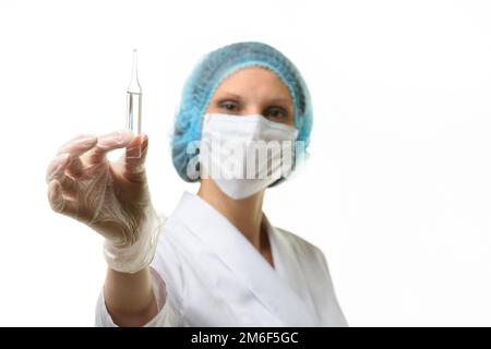 Ärztin in einer medizinischen Maske hält eine Ampulle mit Medizin in ihrer Hand Stockfoto