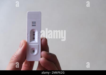 Nahaufnahme der Hand mit positivem COVID-19-Schnelltest. Stockfoto