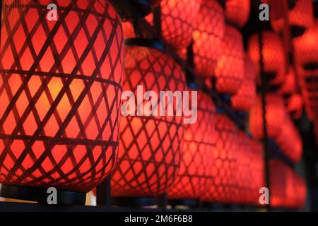 Schließen Sie eine Reihe roter chinesischer Retro-Laternen bei Nacht Stockfoto