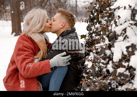 Porträt eines jungen, schönen, lächelnden Paares, das auf der Straße posiert. Verstanden, leerer Platz. Termine im Winter Stockfoto