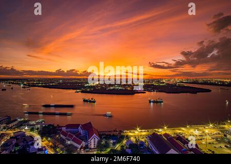Vogelperspektive auf Samut Prakan, Thailand. Sonnenuntergang über dem Chao Phraya Fluss, orangefarbener Himmel. Stockfoto