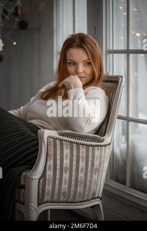 Schönheitsporträt der finnischen skandinavischen Typ kaukasischen Frau sitzt auf Stuhl Stockfoto